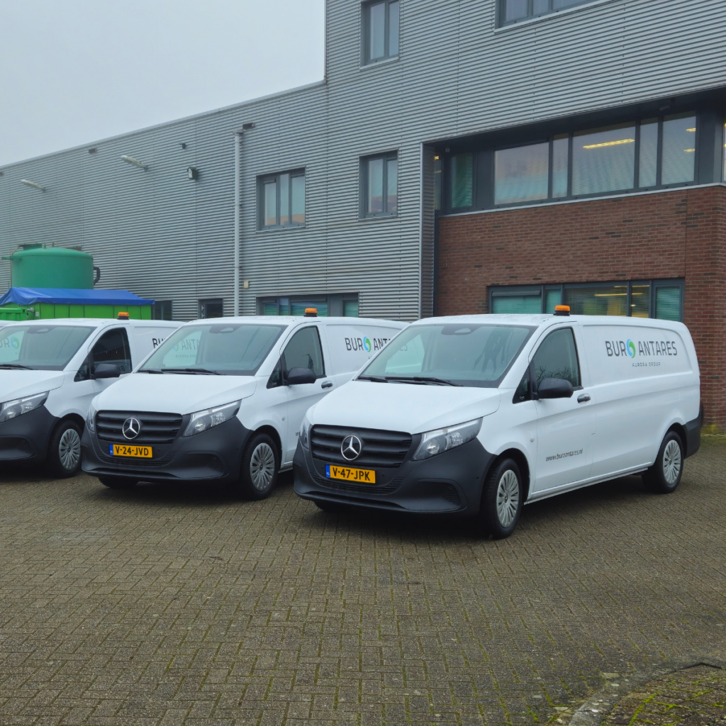 Twee witte veldwerkbussen van Buro Antares naast het bedrijfspand