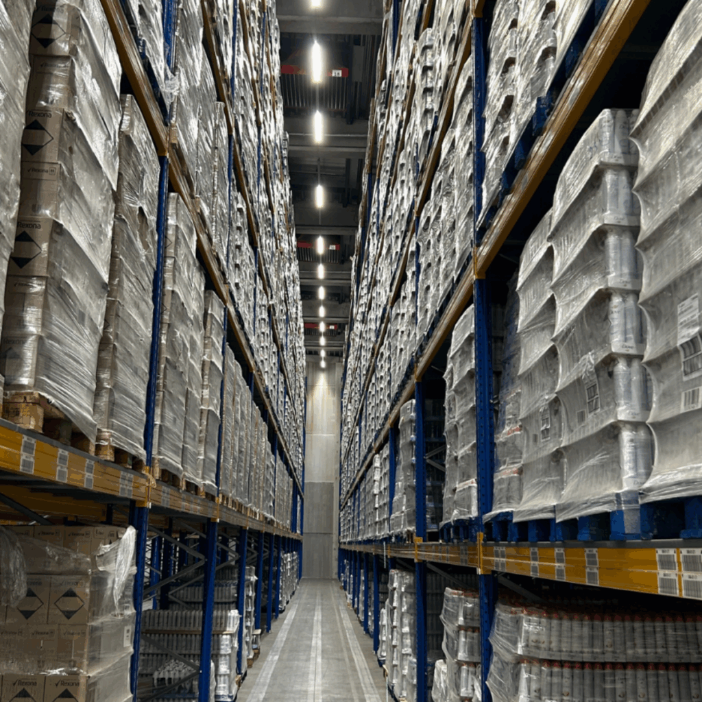 Pallets met opgeslagen goederen in hoge magazijnstellingen