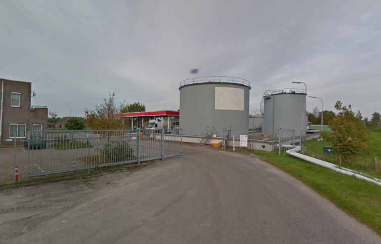 Terrein met opslagtanks langs een weg