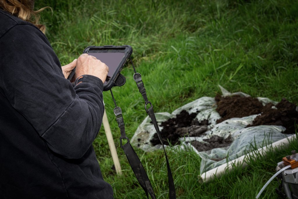 Veldmedewerker van Buro Antares registreert meetgegevens op een tablet tijdens een grondboring